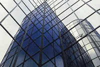 Photographic view of top of skyscraper  seen from alonsgide its base looking through latticed glazing. 
